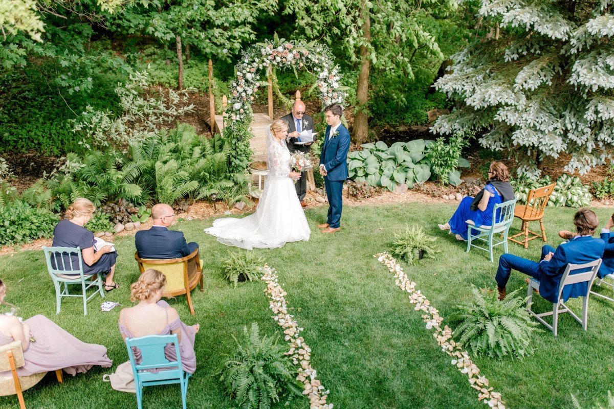Floral arch behind backyard ceremony