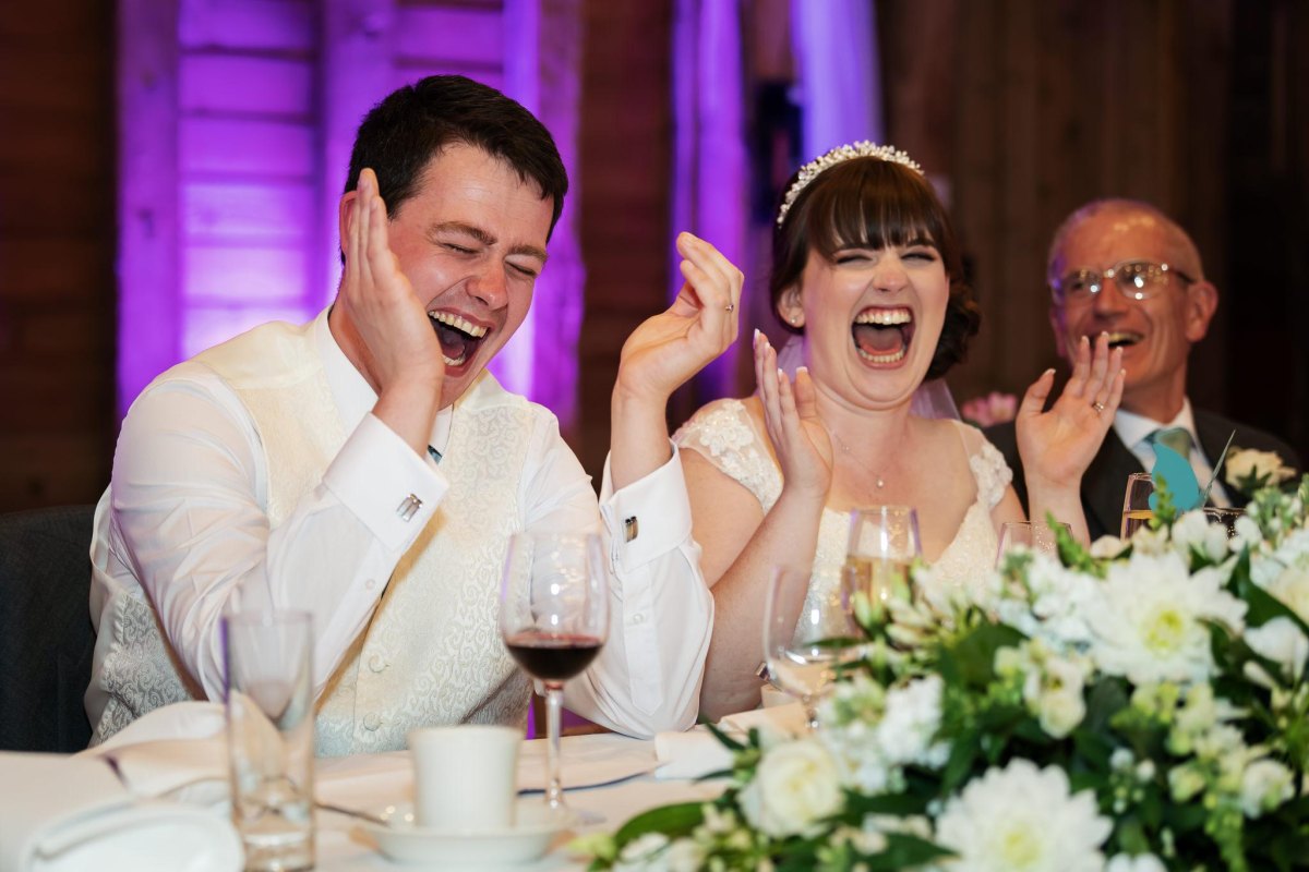 Guests laughing during wedding toast