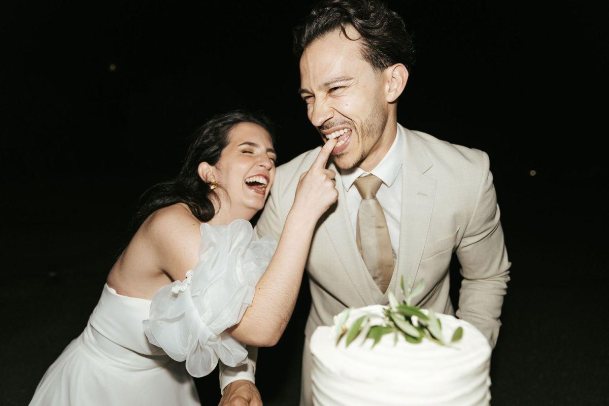 Newlyweds sharing cake and laughing