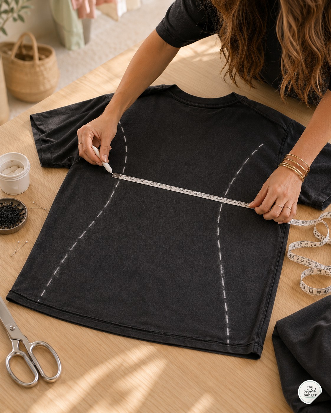 Chalk lines drawn on a flat graphic tee showing the shaped waist and hem for a t-shirt dress DIY.