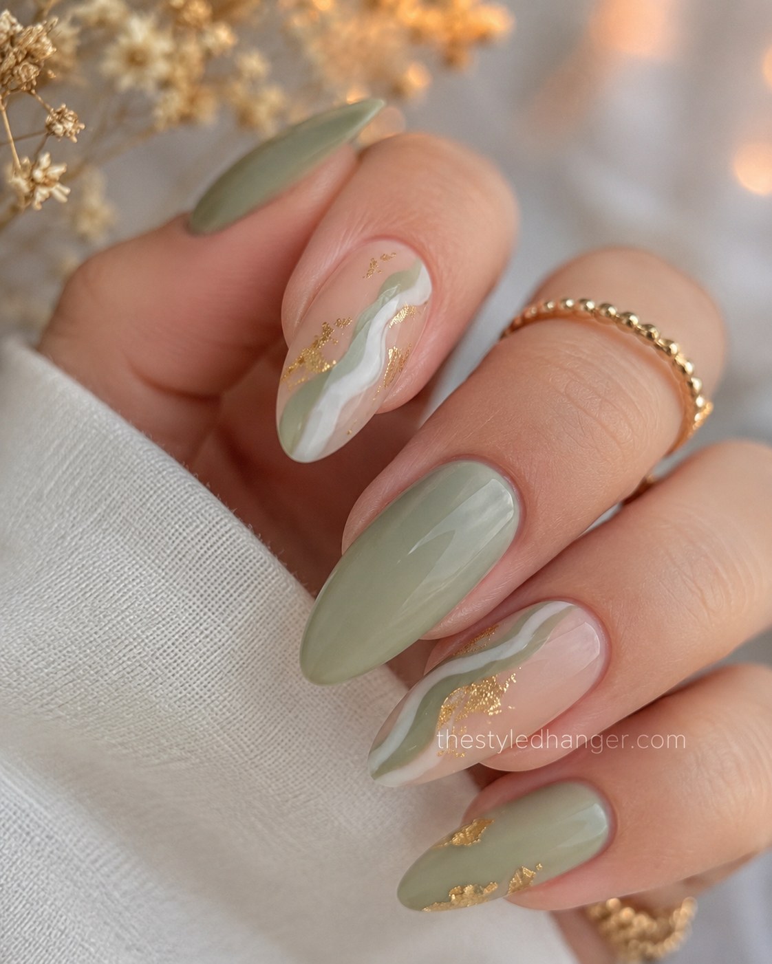Sage green paired with a gold foil swirl accent is one of the prettiest green nail shades for fall.