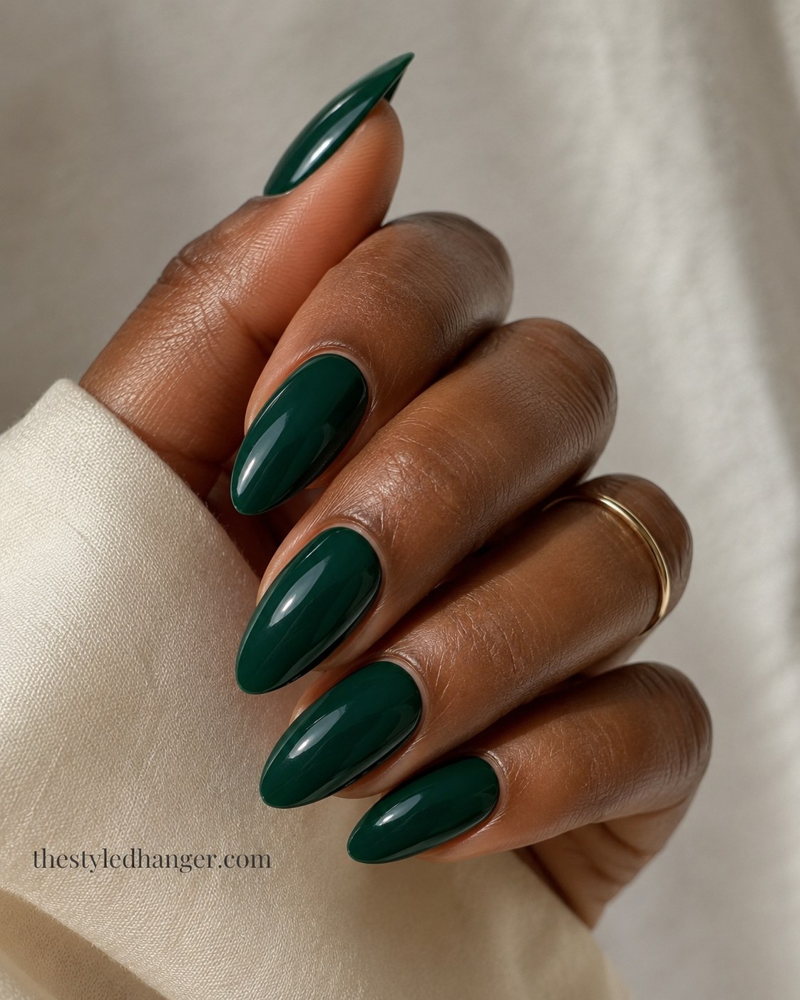 A glossy hunter green manicure proves how rich green nail shades look on deeper skin tones.