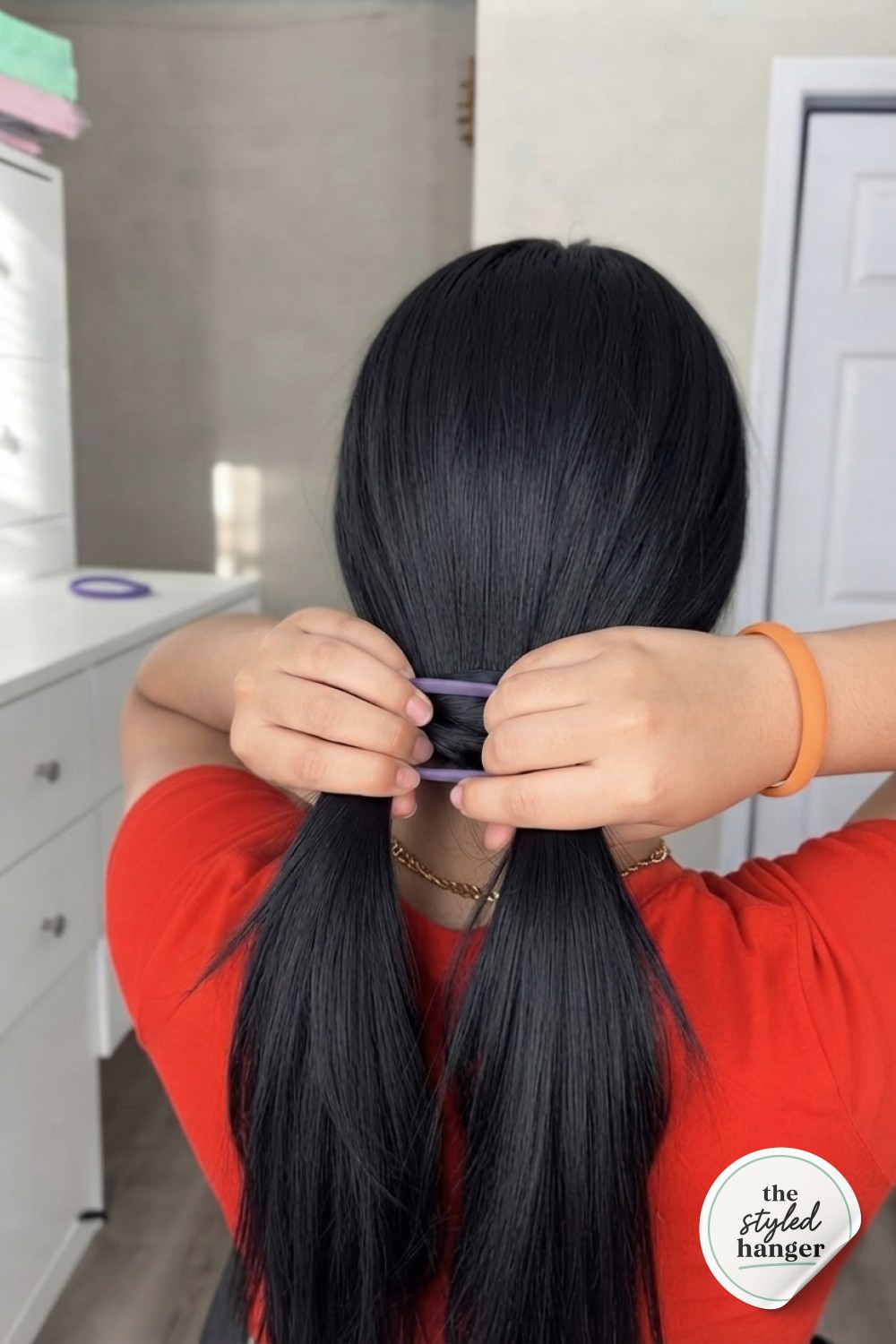 Wrapping the first hair tie around the base during the hair tie ponytail hack process