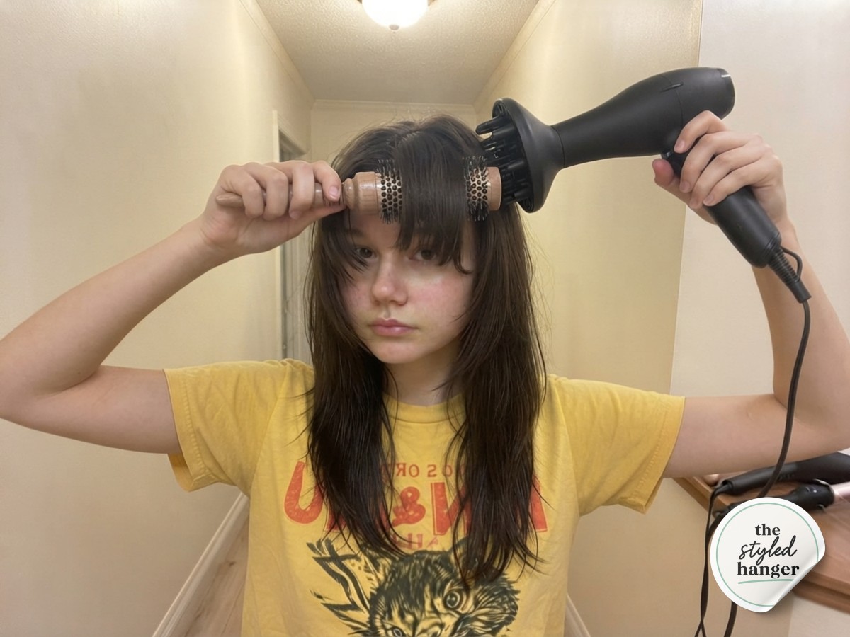 Blow-drying soft curtain bangs with a small round brush for a medium length wolf cut face frame
