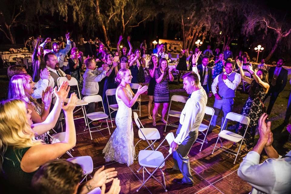 Outdoor wedding guests playing musical chairs