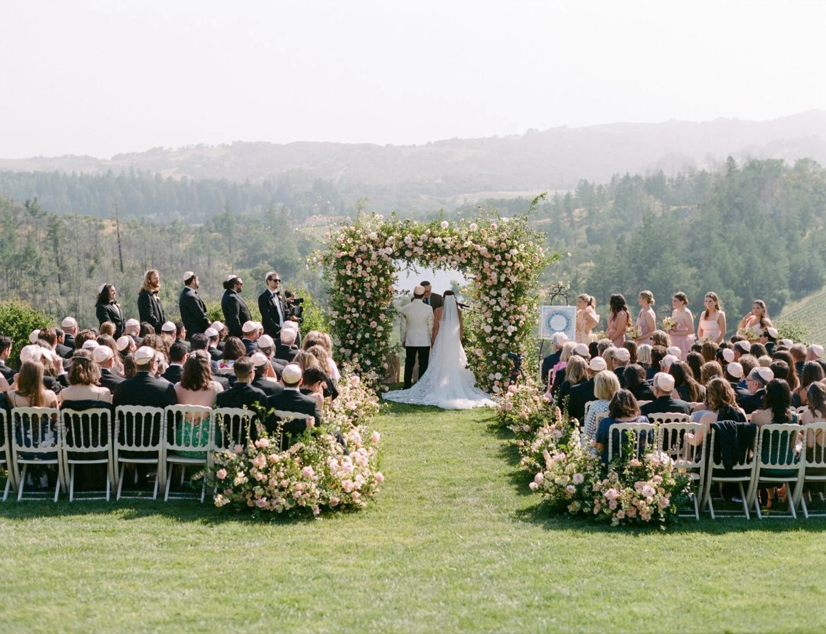 Outdoor wedding ceremony floral arch