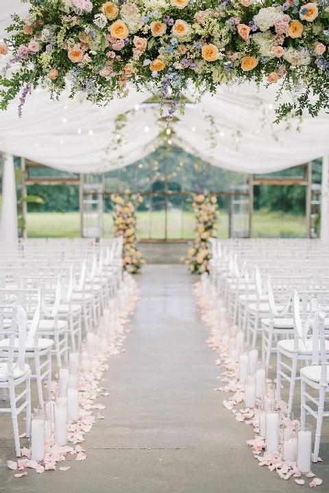 Hanging pastel flowers over wedding aisle