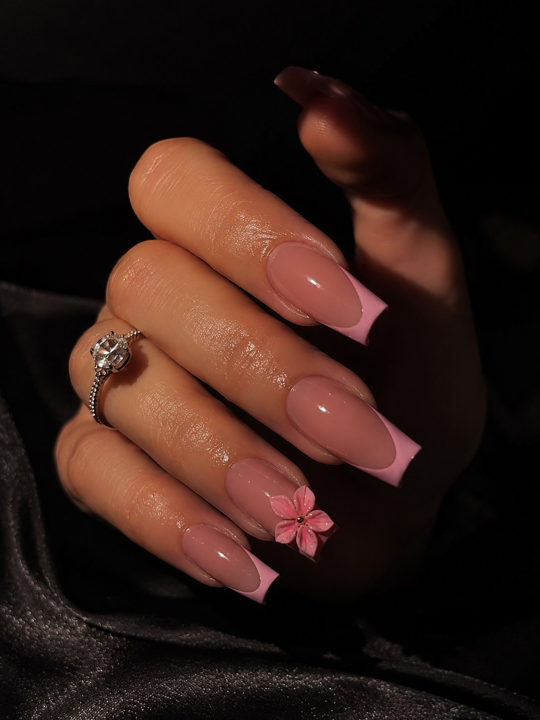 Long coffin nails in a nude-to-pink ombre with a single pressed flower accent