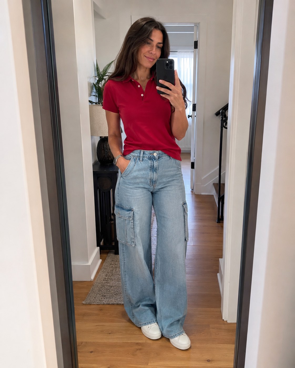 Woman checking her red polo cargo outfit in a mirror