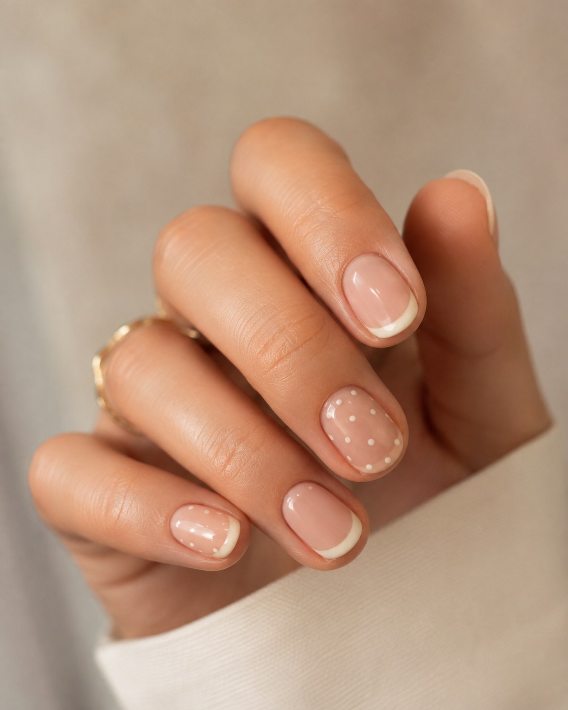 Classic French manicure with a white polka dot accent nail on short natural nails