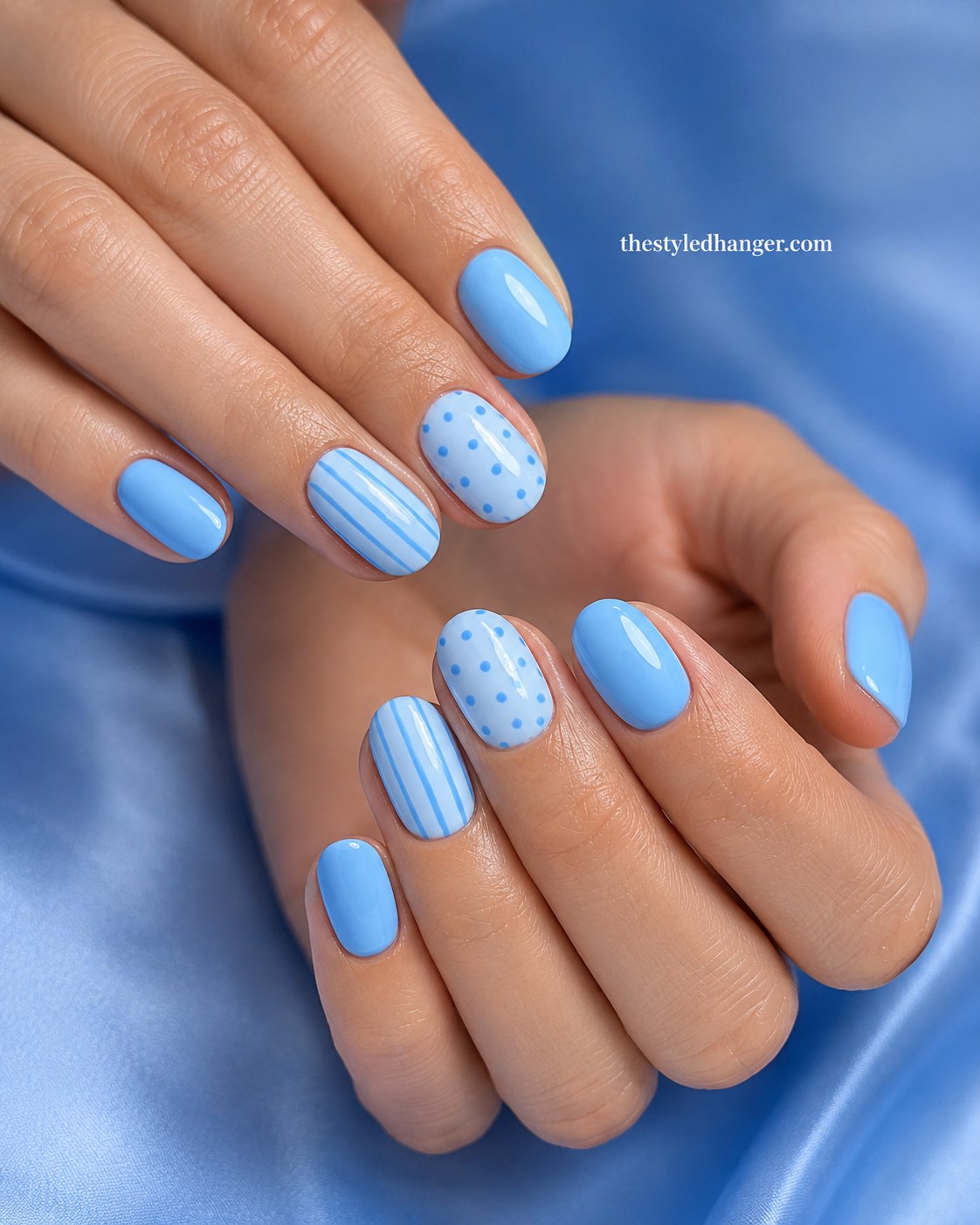 Powder blue nails with polka dot and stripe accents, a soft summer nail color for dark skin