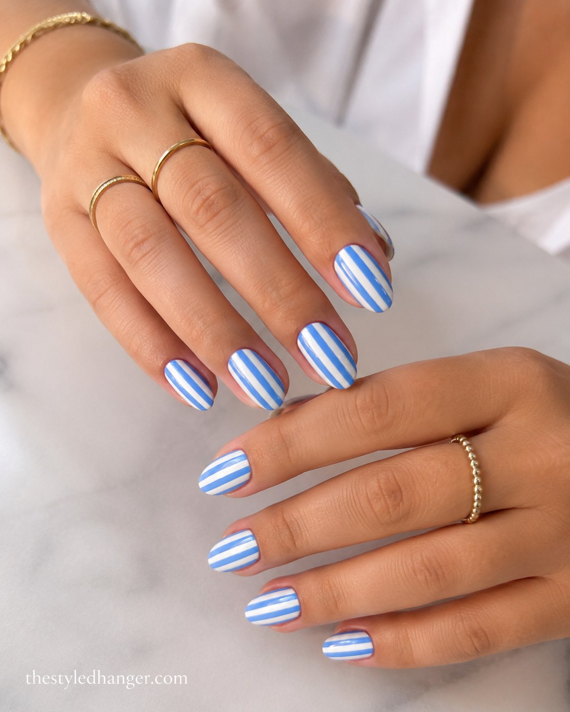 Cornflower blue and white striped nails, a graphic summer nail color for dark skin